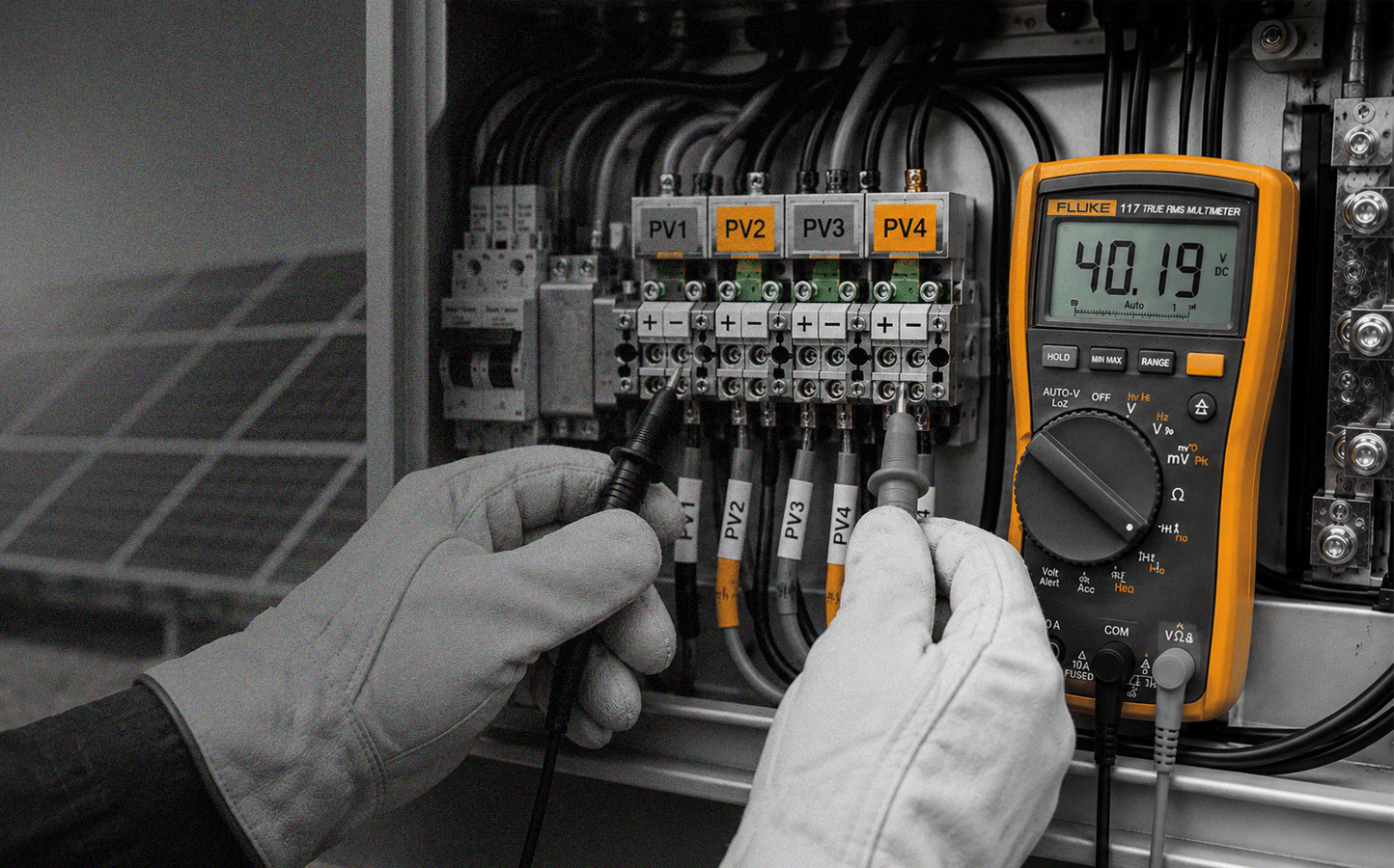 Person using a multimeter to check electrical connections in a panel.